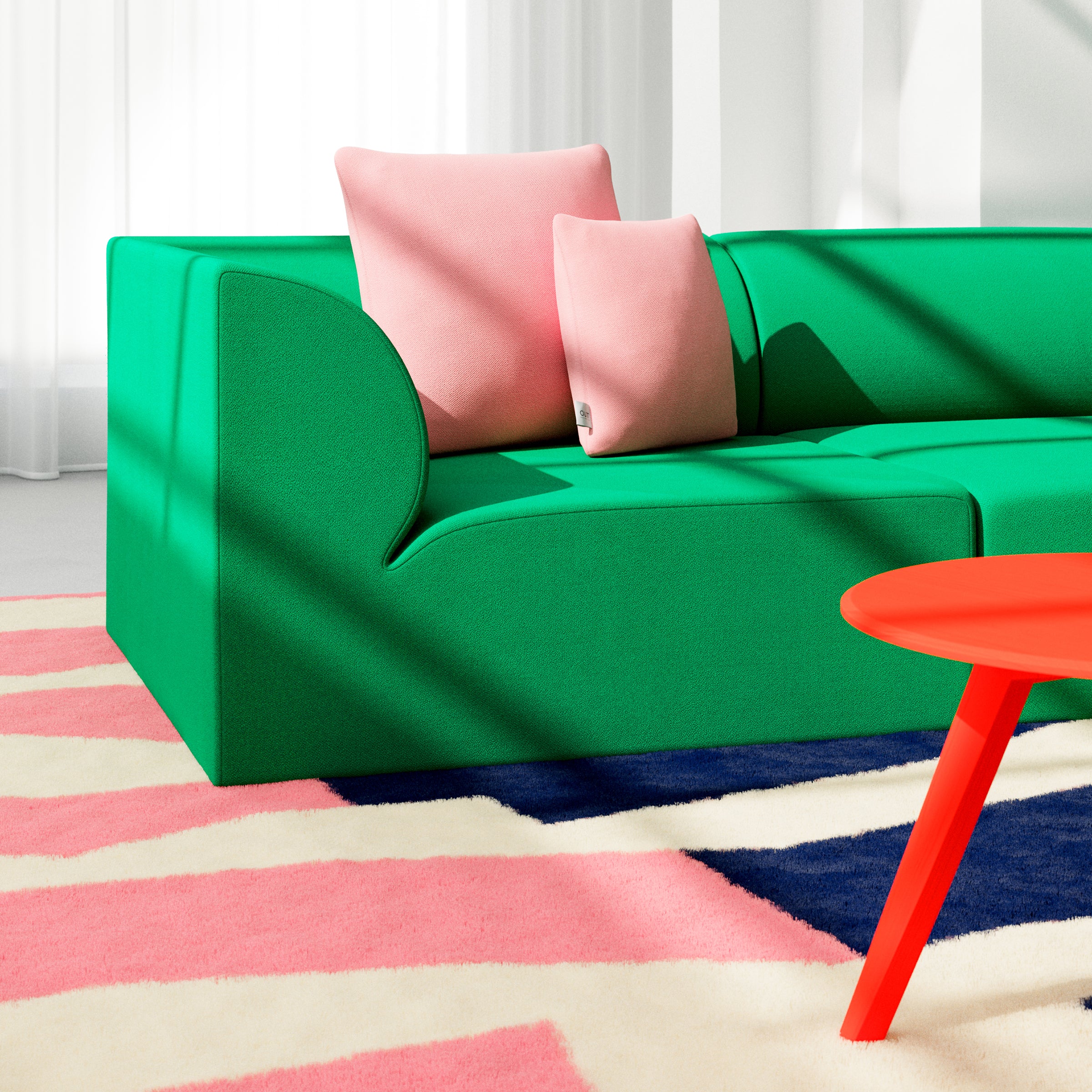 A modern living room showcases an Objekte unserer Tage Weber Modular Sofa in vibrant green with two pink cushions. A carpet displays pink, white, and navy geometric patterns. A small round red table sits before the sofa as sunlight filters through sheer curtains, evoking German sensuality.