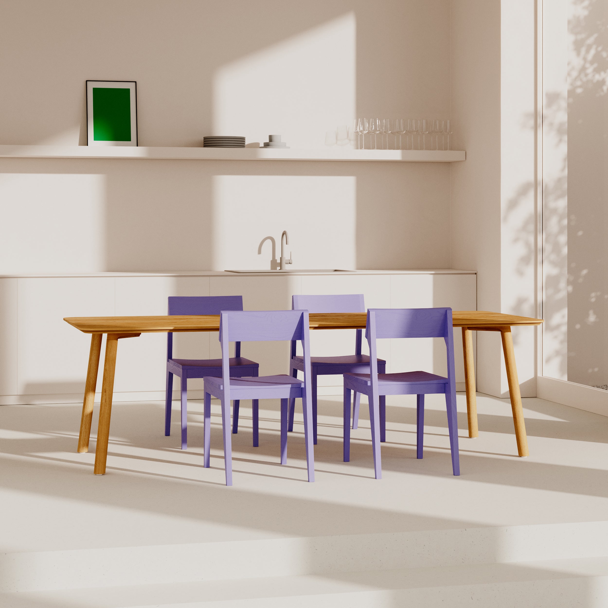 A minimalist dining room showcases the Meyer 23 Table by Objekte unserer Tage, surrounded by four purple chairs. Sunlight softly illuminates the white walls. A shelf holds a framed green picture, plates, and glasses, and a sink in the background highlights sustainable production.