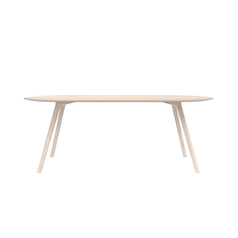 Introducing the Meyer Table by Objekte unserer Tage: a minimalist design with an oval solid ash top and elegantly slanted legs. Its light finish adds serene elegance, enhancing any space against a plain white background.