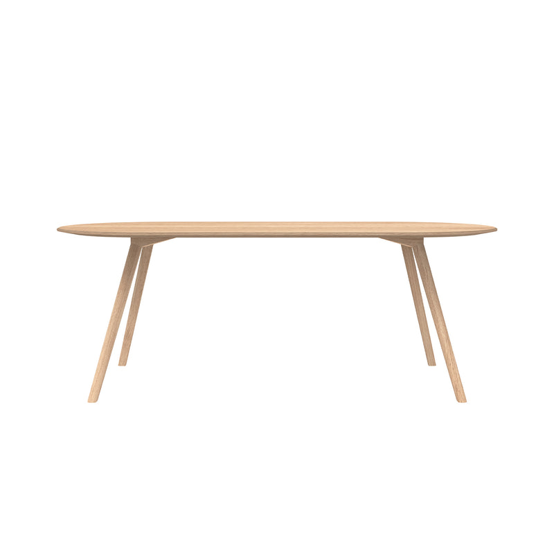 The Meyer Table from Objekte unserer Tage showcases a minimalist design, featuring an elongated oval solid ash top and four angled legs, standing elegantly against a plain white background.