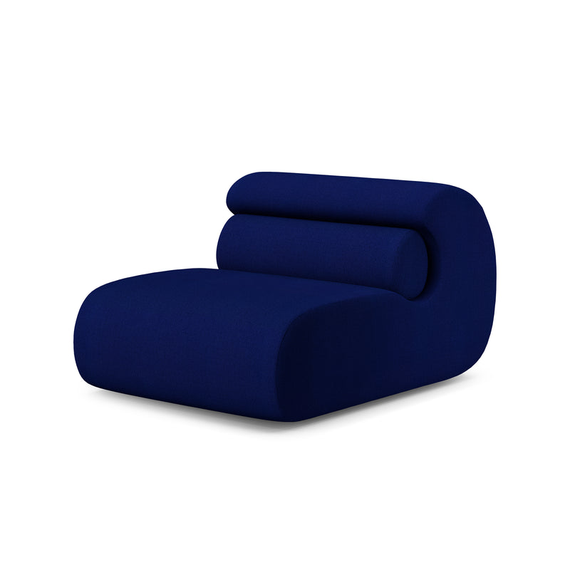 The Ola Sofa by Objekte unserer Tage is a modern, minimalist piece upholstered in Mediterranean Sea-like dark blue fabric, with a memory foam low wide seat and a curved backrest smoothly merging into the base for a flowing silhouette.