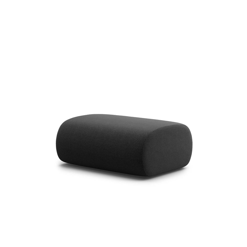 The dark gray Ola Pouf by Objekte unserer Tage, featuring a rectangular shape with rounded edges and memory foam cushioning, complements the OLA Sofa beautifully against its white background.