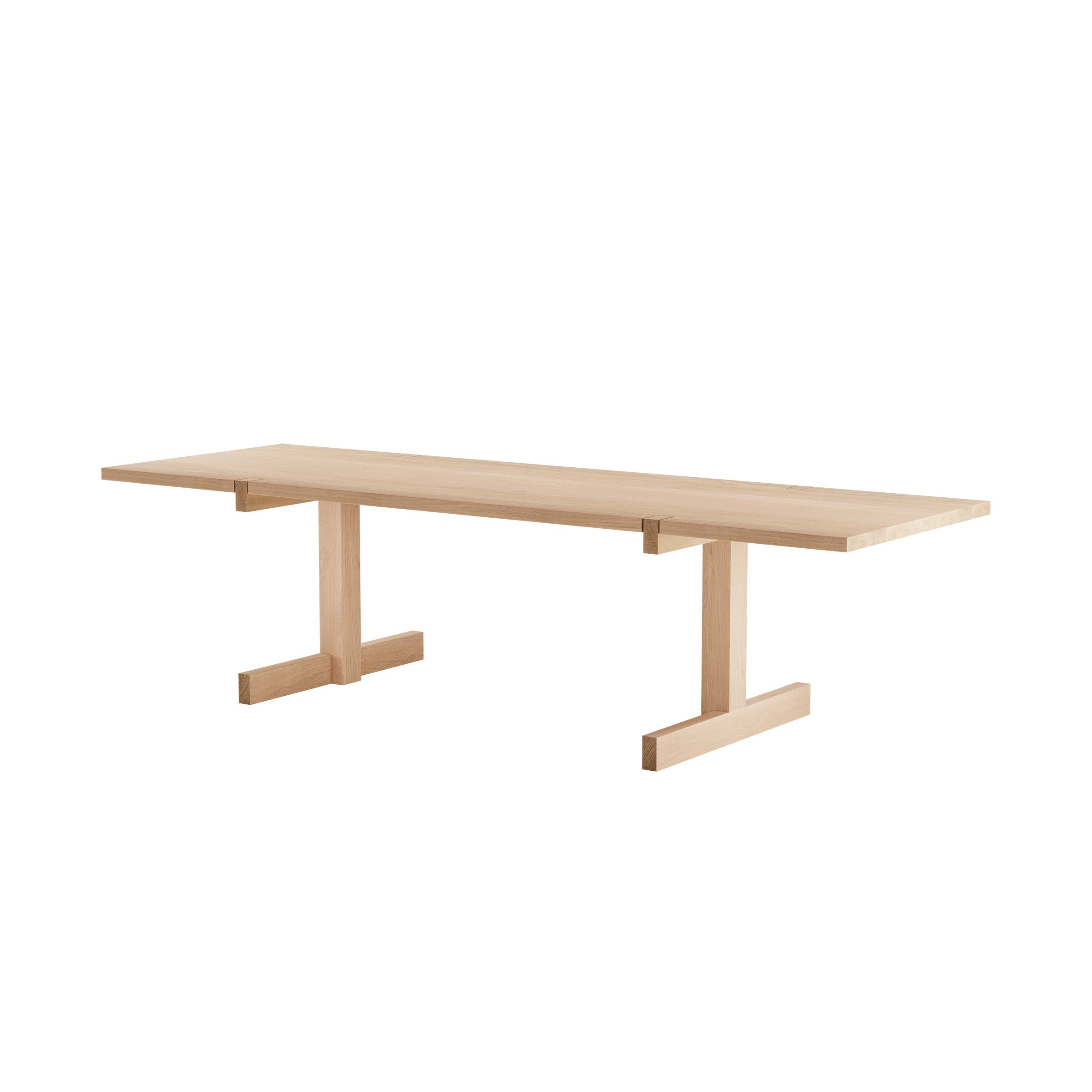 The Richter Table by Objekte unserer Tage is a minimalist, rectangular wooden table with a light finish. Handcrafted from sustainable forestry, it features a flat top and two perpendicular support legs joined by a central horizontal beam.